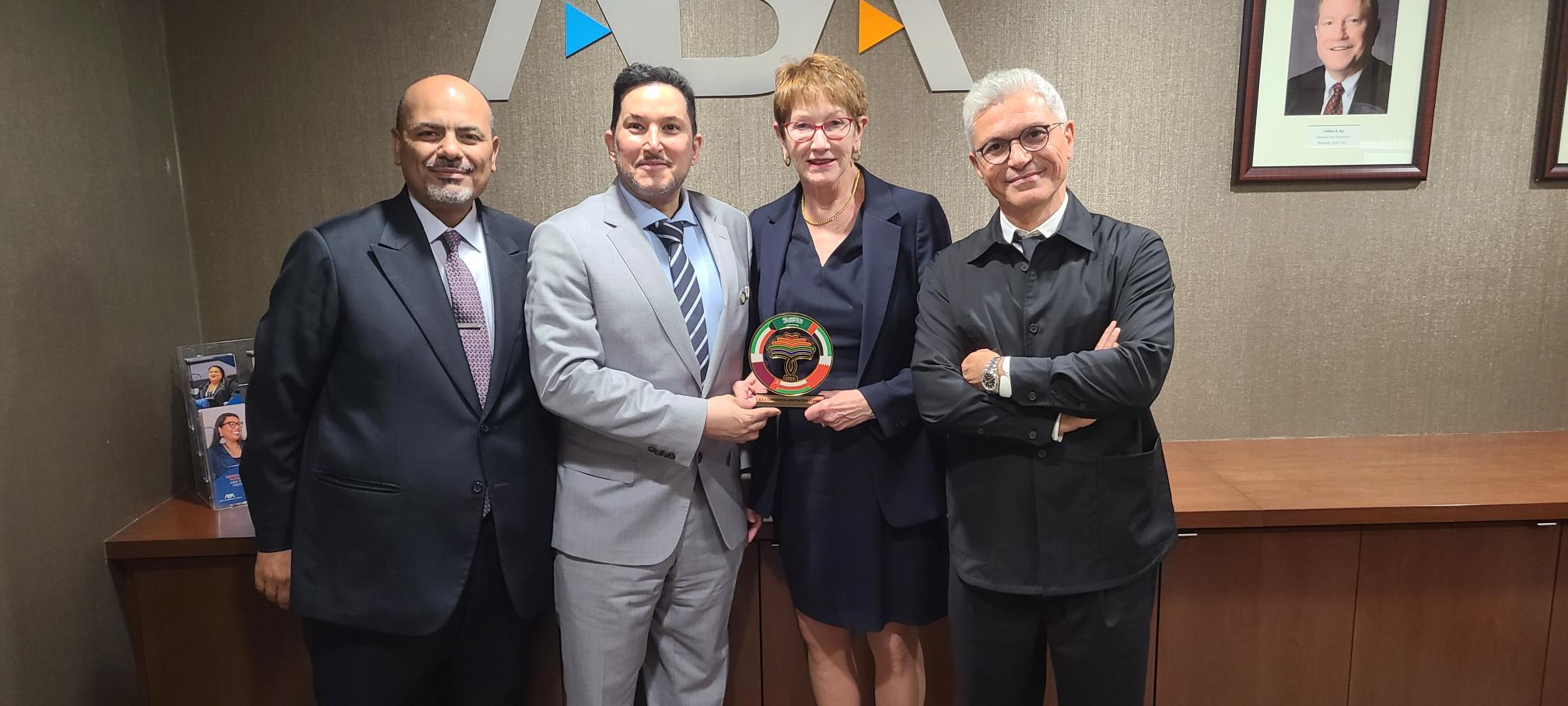 An image of a group of people holding an award, including , Judge Susan G. Braden, Majed M Garoub, Cha, Dr. Kamal Al-Hamad, and Mr. Sami Houerbi
